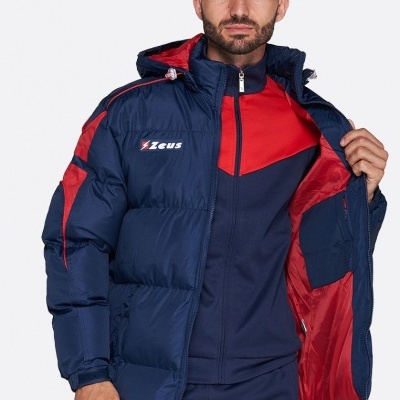 Homem com casaco acolchoado azul e vermelho e roupa desportiva azul e vermelha com logo ZEUS