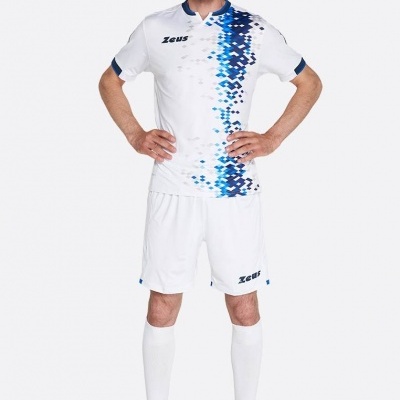 Homem com uniforme desportivo branco com padrão azul e sapatilhas amarelas.