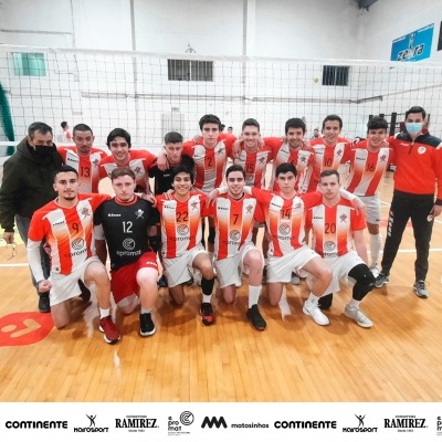 Equipa de voleibol em pavilhão com rede e equipamento laranja e branco