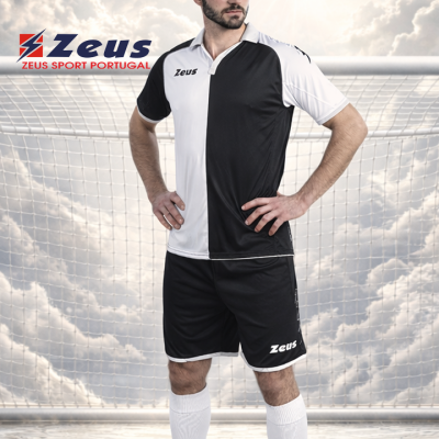 Jogador de futebol com uniforme Zeus preto e branco em frente a rede de baliza.