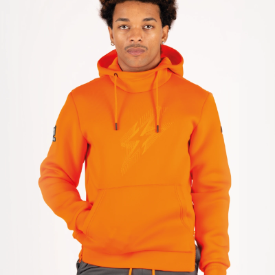 Homem a usar casaco com capuz laranja com padrão de raios no peito e bolso frontal, com calças cinzentas