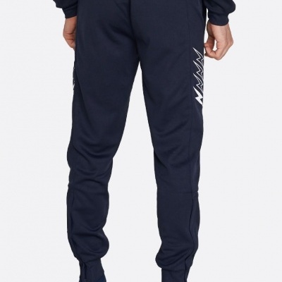 Calças de treino pretas vista traseira com pormenores brancos e sapatos azuis