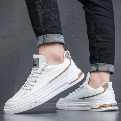 Sapatilhas brancas com detalhes marrons usadas por pessoa com jeans pretos