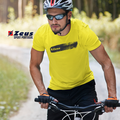Homem com capacete e óculos a usar t-shirt amarela Zeus e luvas de ciclismo