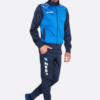 Homem com fato de treino azul e preto com logotipo Zeus, calçado desportivo azul, fundo branco