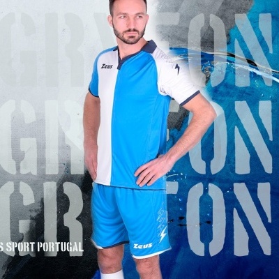 Homem com fato desportivo azul e branco Zeus com texto Zeus Sport Portugal em fundo azul e cinzento