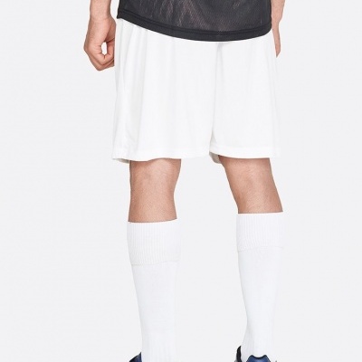 Homem de costas com calções brancos, meias brancas e sapatos desportivos azuis.