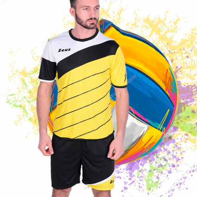 Homem veste equipamento de futebol amarelo, preto e branco com bola de futebol colorida ao fundo
