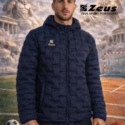 Homem com casaco e calças desportivas azuis com logo Zeus em campo desportivo e estátuas gregas ao fundo