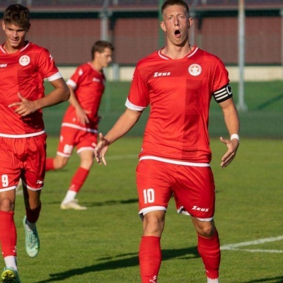 Jogadores de futebol em campo com uniformes vermelhos e números 9 e 10