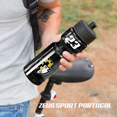 Garrafa preta com emblema do Sporting e números 123, segurada junto a bicicleta.