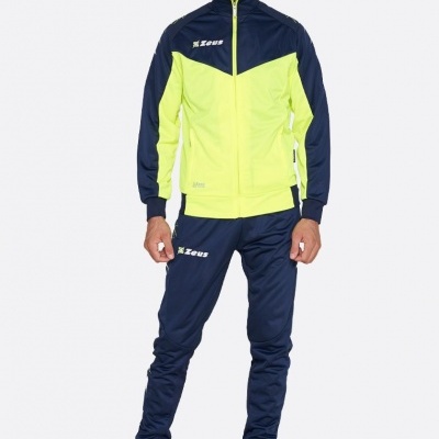 Homem com conjunto desportivo amarelo fluorescente e azul escuro Zeus, com sapatilhas azuis