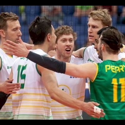 Jogadores de voleibol em ação com uniformes brancos, verdes e amarelos