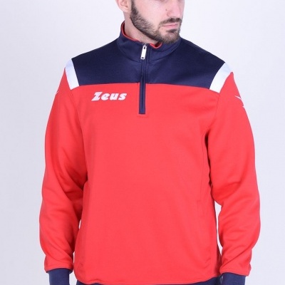 Homem a usar sweatshirt vermelha e azul-escuro com fecho de meio zíper e calças azuis com detalhes vermelhos e brancos