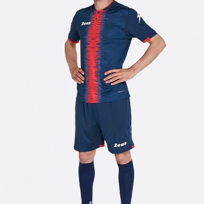 Homem com conjunto desportivo azul escuro e vermelho, meias longas azuis e sapatilhas azuis e amarelas