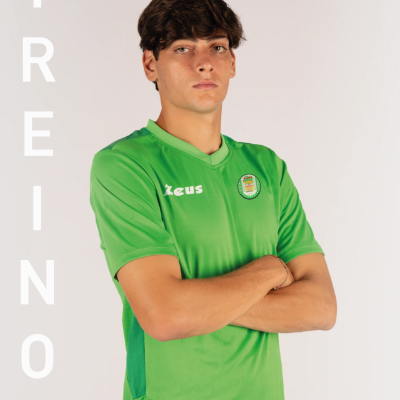 Homem usando t-shirt verde desportiva com logótipos Zeus e emblema redondo, palavra TREINO ao lado