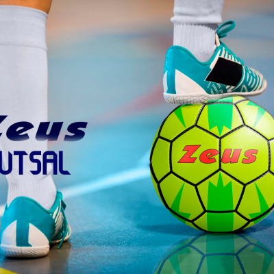 Pessoa com sapatilhas azul turquesa a apoiar bola de futsal verde amarela com texto Zeus em campo indoor