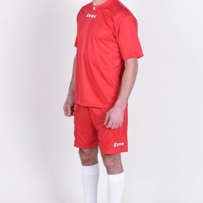 Homem com roupa desportiva vermelha da marca Zeus, meias brancas e ténis pretos, fundo branco.