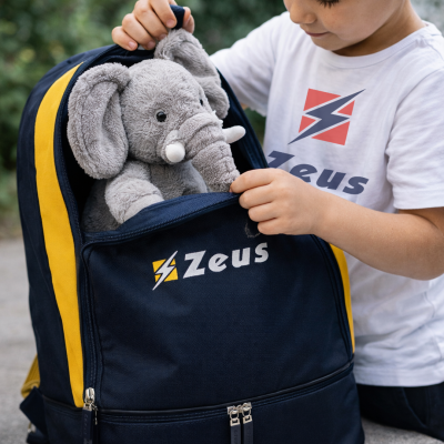 Mochila azul e amarela com peluche de elefante e criança a segurar a mochila