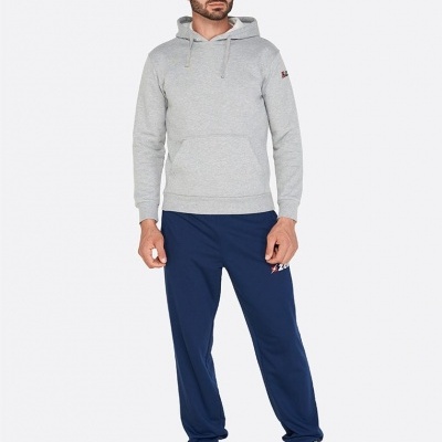 Homem com hoodie cinzento e calças desportivas azul escuro com sapatilhas azuis