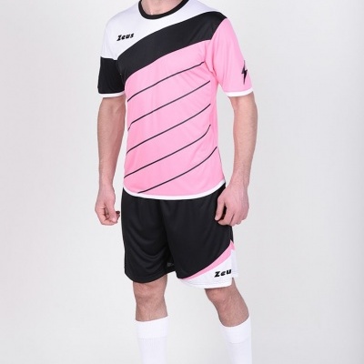Homem com conjunto desportivo rosa, preto e branco com texto Zeus, usado com meias brancas e sapatilhas pretas