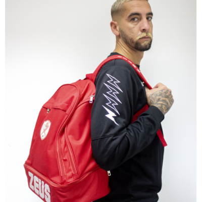 Homem a usar mochila vermelha com texto ZEUS e sweatshirt preta com desenhos brancos