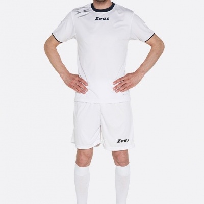 Homem com fato desportivo branco e sapatos escuros em fundo branco