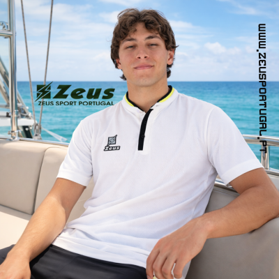 Homem jovem com polo branco Zeus, sentado num barco com o mar azul ao fundo.