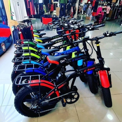 Fila de bicicletas elétricas coloridas em loja com piso de azulejo