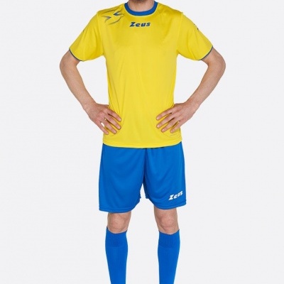 Homem vestido com conjunto de roupa desportiva amarela e azul, fundo branco.