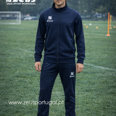 Homem com fato de treino azul escuro e logótipo Zeus branco em campo de futebol