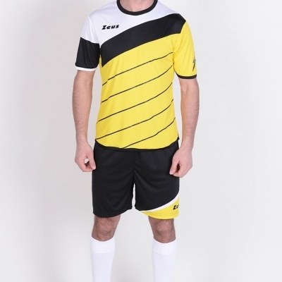 Homem com fato de treino amarelo, preto e branco em fundo branco.