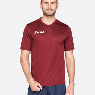 Homem com t-shirt vinho e calções azuis escuros com texto Zeus