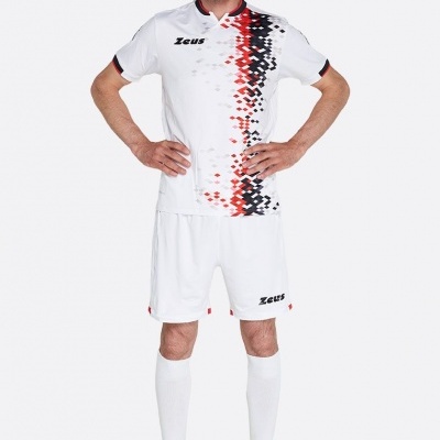 Homem com fato de futebol branco com padrão pixelado vermelho e preto, meias e calçado desportivo amarelo e preto