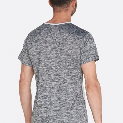 Homem de costas com t-shirt cinza mesclada e calças escuras