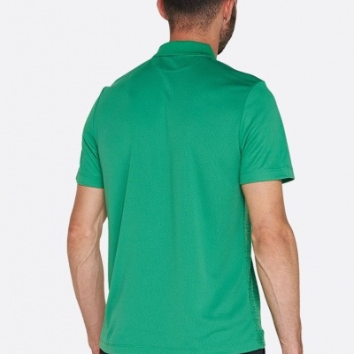 Homem de costas a usar t-shirt polo verde de manga curta e calças escuras