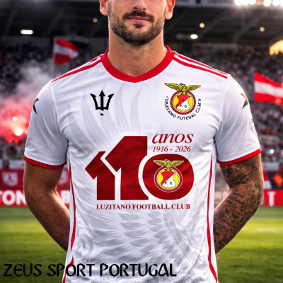 Camisola de futebol branca com detalhes vermelhos e logótipo de clube exibida em estádio