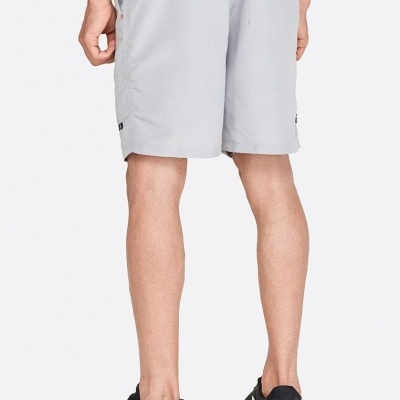 Calções masculinos cinzentos claros e ténis pretos com sola branca