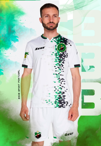 Homem em equipamento desportivo branco com padrão pixelado verde e preto, marca Zeus visível.