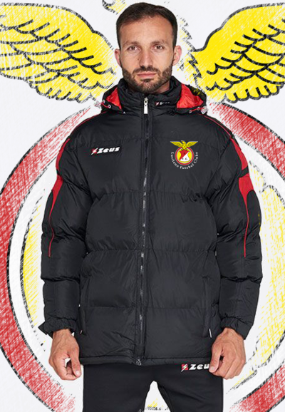Homem com casaco acolchoado preto e vermelho com logótipos do Benfica e Zeus em fundo desenhado com asinhas amarelas.