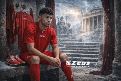 Conjunto desportivo vermelho Zeus e sapatilhas num cenário antigo de pedra com estátua e cortinas vermelhas.