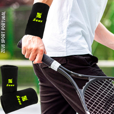 Bracelete desportivo preto com logotipo Zeus em verde junto a raquete de ténis