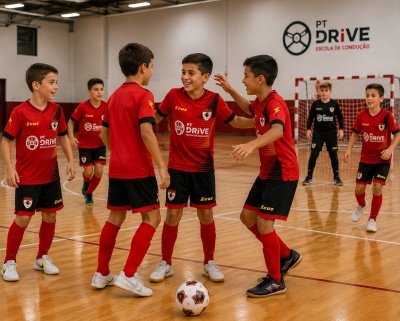 Jogadores jovens de futsal em campo com camisolas vermelhas e calções pretos