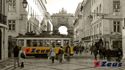 Elétrico amarelo clássico com letreiro Zeus em rua de Lisboa em tom sépia