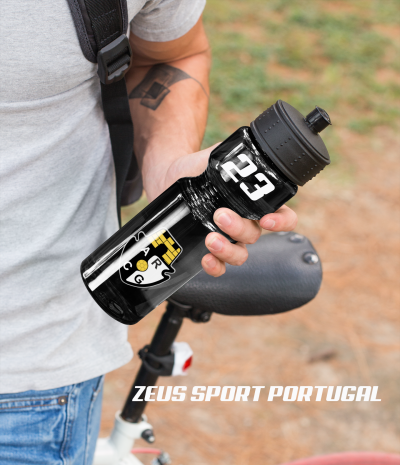 Garrafa preta com emblema do Sporting e números 123, segurada junto a bicicleta.