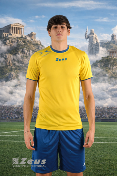 Homem com t-shirt amarela e calções azuis de treino Zeus num campo de futebol com estádios e estátuas antigas ao fundo