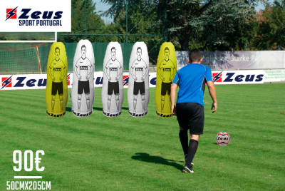 Campo de futebol com homem a chutar bola e manequins de treino Zeus insufláveis