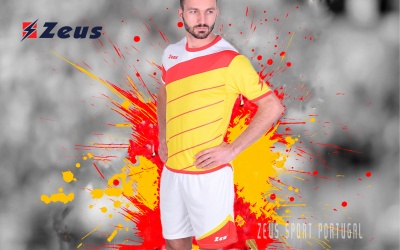 Conjunto desportivo amarelo e vermelho com calções brancos, logótipo Zeus, fundo colorido