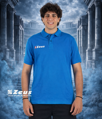 Homem jovem com polo azul com logotipo Zeus em fundo de ruínas e névoa azul