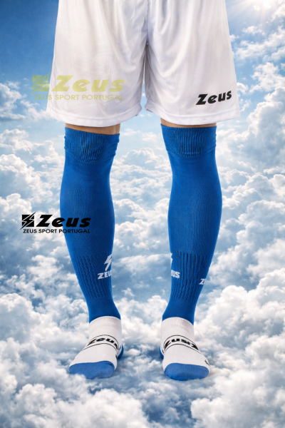 Calções de futebol brancos com meias azuis e peúgas brancas e azuis com logos Zeus, fundo de céu com nuvens